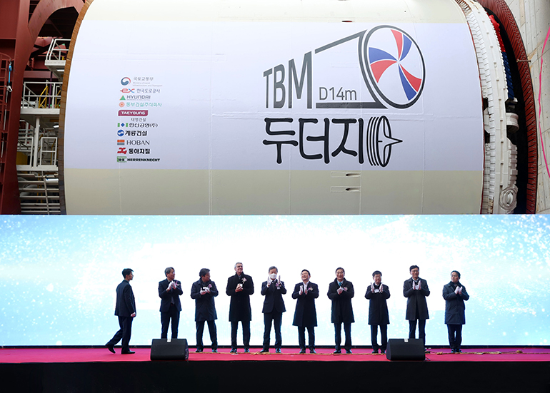 Officials from government agencies and construction companies, including Hyundai E&C President Yoon Young-joon (right) and Korea Expressway Corporation acting CEO Kim Il-hwan (left) with Won Hee-ryong, Minister of Land, Infrastructure and Transport (fifth from the right), are taking commemorative photos at the Han River Tunnel TBM Tunneling Ceremony in the Gimpo-Paju Section 2. 